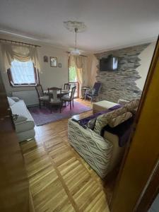 a living room with a couch and a stone wall at Apartman Cici in Zlatibor