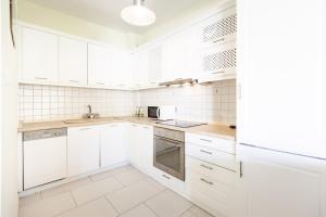 a white kitchen with white cabinets and appliances at Diamanti Villa, Pool & Barbecue in Skala Potamias