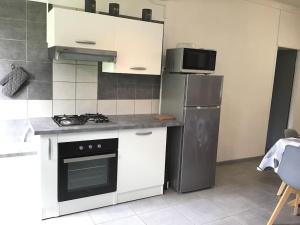 a kitchen with a stove and a refrigerator at La Case Michou, calme et confort in La Plaine des Palmistes