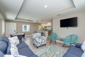 uma sala de estar com um sofá azul e cadeiras em AMI Gulf Lookout-Views Of The Gulf From Every Room-Rooftop Terrace em Bradenton Beach