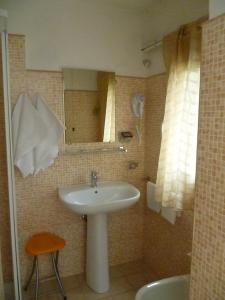 łazienka z umywalką i lustrem w obiekcie Hotel Pensione Romeo w mieście Bari