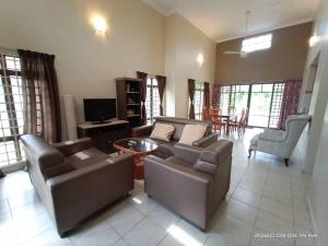 a living room with two couches and a tv at Villa with Private Swimming Pool in Melaka