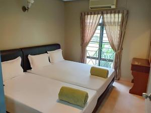 a bedroom with a large white bed with a window at Villa with Private Swimming Pool in Melaka