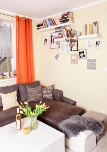 a living room with a brown couch and orange curtains at 2-izbový Apartmán Mlynica s balkónom in Mlynica