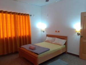 a small bedroom with a bed and two lights at Lovely 3-bedroom vacation home in Kumasi in Kumasi