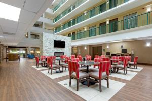 a dining room with red chairs and tables and a fireplace at Comfort Suites Near Potomac Mills in Woodbridge