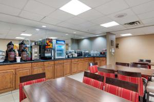 a restaurant with wooden tables and chairs and a counter at Comfort Inn Anderson South in Anderson