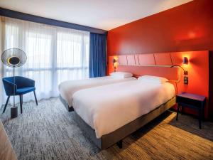 una habitación de hotel con 2 camas y una silla en Mercure Thalasso & Spa Port Fréjus, en Fréjus