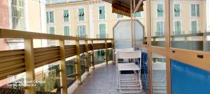 サンレモにあるSanremo DOLCE DORMIREのはしごと椅子付きの建物のバルコニー