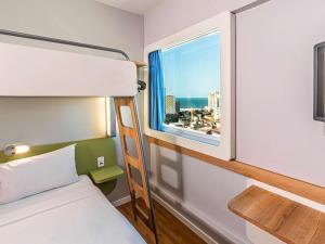sypialnia z łóżkiem piętrowym i oknem w obiekcie Ibis Budget Fortaleza Praia de Iracema w mieście Fortaleza