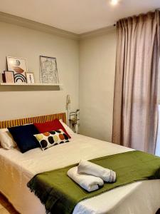 ein Schlafzimmer mit einem Bett mit zwei Handtüchern darauf in der Unterkunft La casa de Talo in Granada