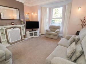 a living room with a couch and a tv at Carlyn in Caernarfon