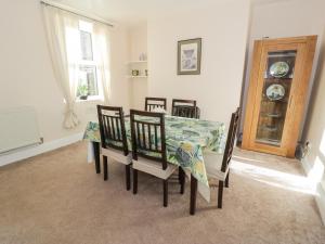 a dining room with a table and chairs and a window at Carlyn in Caernarfon