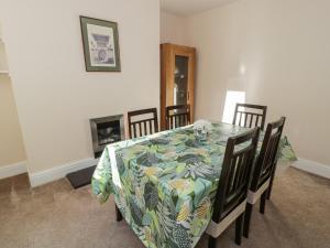 a dining room with a table and chairs and a fireplace at Carlyn in Caernarfon +16 photos