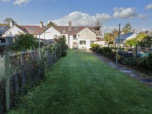 a yard with a fence and a house at Carlyn in Caernarfon
