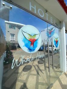 Una ventana de una tienda con un cartel. en Whale House Hotel, en Puerto López