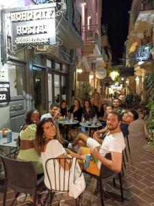 een groep mensen die 's nachts in een restaurant zitten bij Boho City Hostel in Chania