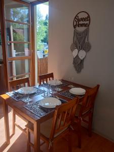 a dining room table with chairs and a sign that reads sweet home at Słoneczny Apartament w centrum pięknych Karkonoszy in Jelenia Góra