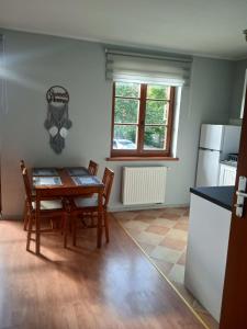 a kitchen and dining room with a table and chairs at Słoneczny Apartament w centrum pięknych Karkonoszy in Jelenia Góra