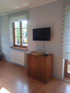 a living room with a flat screen tv on a wall at Słoneczny Apartament w centrum pięknych Karkonoszy in Jelenia Góra