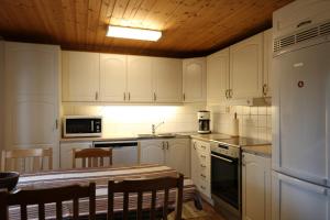a kitchen with white cabinets and a table and chairs at Holiday house in Gnosjo with amazing lake view in Gnosjö
