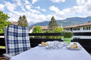 a table with food on a balcony with mountains at Alpenkette in Garmisch-Partenkirchen
