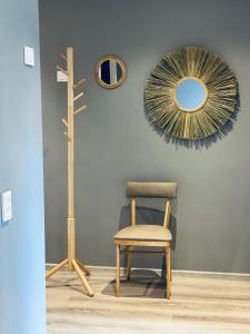 a room with a chair and a mirror at Ramybės apartamentai in Anykščiai