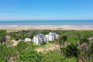 an aerial view of a white house with the ocean in the background at Pinar del Oriental in José Ignacio