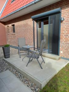 twee stoelen en een tafel op een patio bij Greenments, Apartments für Freizeit und Beruf in Geesthacht