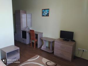 a room with a desk with a tv and a chair at готель ДежаВю in Berdychiv