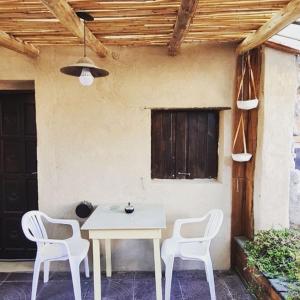Hostal Asqui Pacha في تيلكارا: طاولة بيضاء و كرسيين على فناء