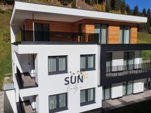 Ein weißes Gebäude mit dem Sonnenschild drauf. in der Unterkunft Sun Lodge in Ischgl