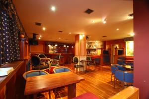 Un restaurante con mesas y sillas y un bar. en Mantas Hotel, en Loutraki