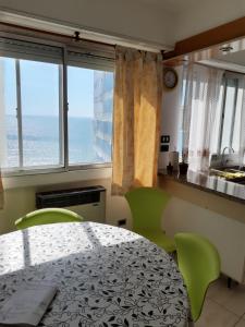 a dining room with a table and chairs and the ocean at Radar Mirador Cabo Corrientes in Mar del Plata