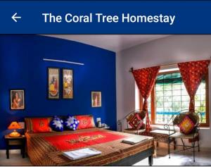 Cette chambre comprend un lit et un mur bleu. dans l'établissement The Coral Tree Boutique Homestay, à Agra