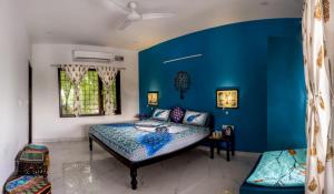 a bedroom with blue walls and a bed at The Coral Tree Boutique Homestay in Agra