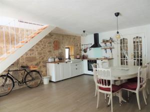 een keuken en eetkamer met een tafel en een fiets bij Refúgio do Anjo - Alojamento Local in Lanhelas