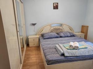 a bedroom with a bed with towels and slippers on it at Hotel Matal in Međugorje