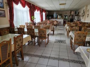 a dining room with many tables and chairs and a room withermottermott at Hotel Matal in Međugorje
