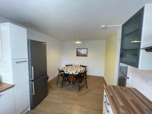 a kitchen and dining room with a table and a refrigerator at Lesmurdie Court, Serviced Accommodation Moray in Elgin +6 photos