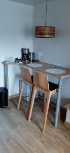 een tafel en stoelen in een kamer met een keuken bij Aux 77 Nuitées in Trilport