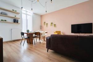 een woonkamer met een bank en een tafel met stoelen bij LocationsTourcoing - Le Winoc in Tourcoing