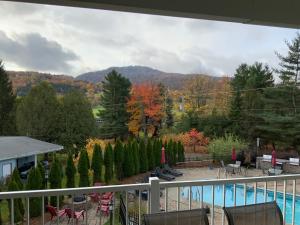 a balcony with a view of a pool and trees at Le Champlain Condo-Hôtel in Bromont