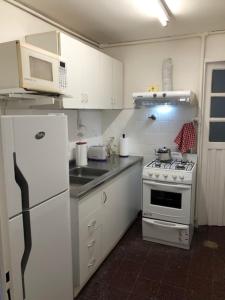 a kitchen with a white stove and a white refrigerator at Confortable dep 3 dorm pasos plaza ppal in Concordia