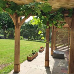 a wooden pergola with potted plants in a park at Wood Rising in Newark upon Trent