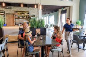 un grupo de personas sentadas en una mesa en un restaurante en RCN Vakantiepark Bungalow de Dukdalf, en Kamperland