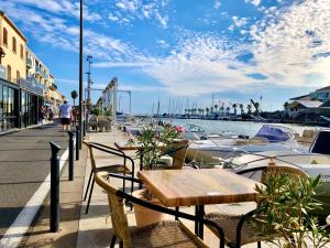 une table et des chaises à côté d'une marina avec des bateaux dans l'établissement 1Bed Cottage Sleeps 4- Sea Views Balcony Parking, à Mèze 28 autres photos