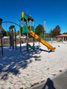 un parque infantil con un tobogán amarillo en la nieve en Mobilhome Salsa XXL, en Gastes