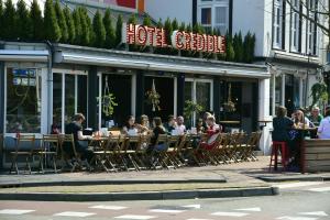 
people sitting on a bench in front of a restaurant at Hotel Credible in Nijmegen
