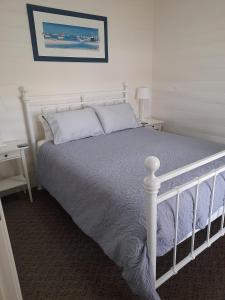 a bedroom with a white bed and two night stands at Addies Place Goolwa in Goolwa